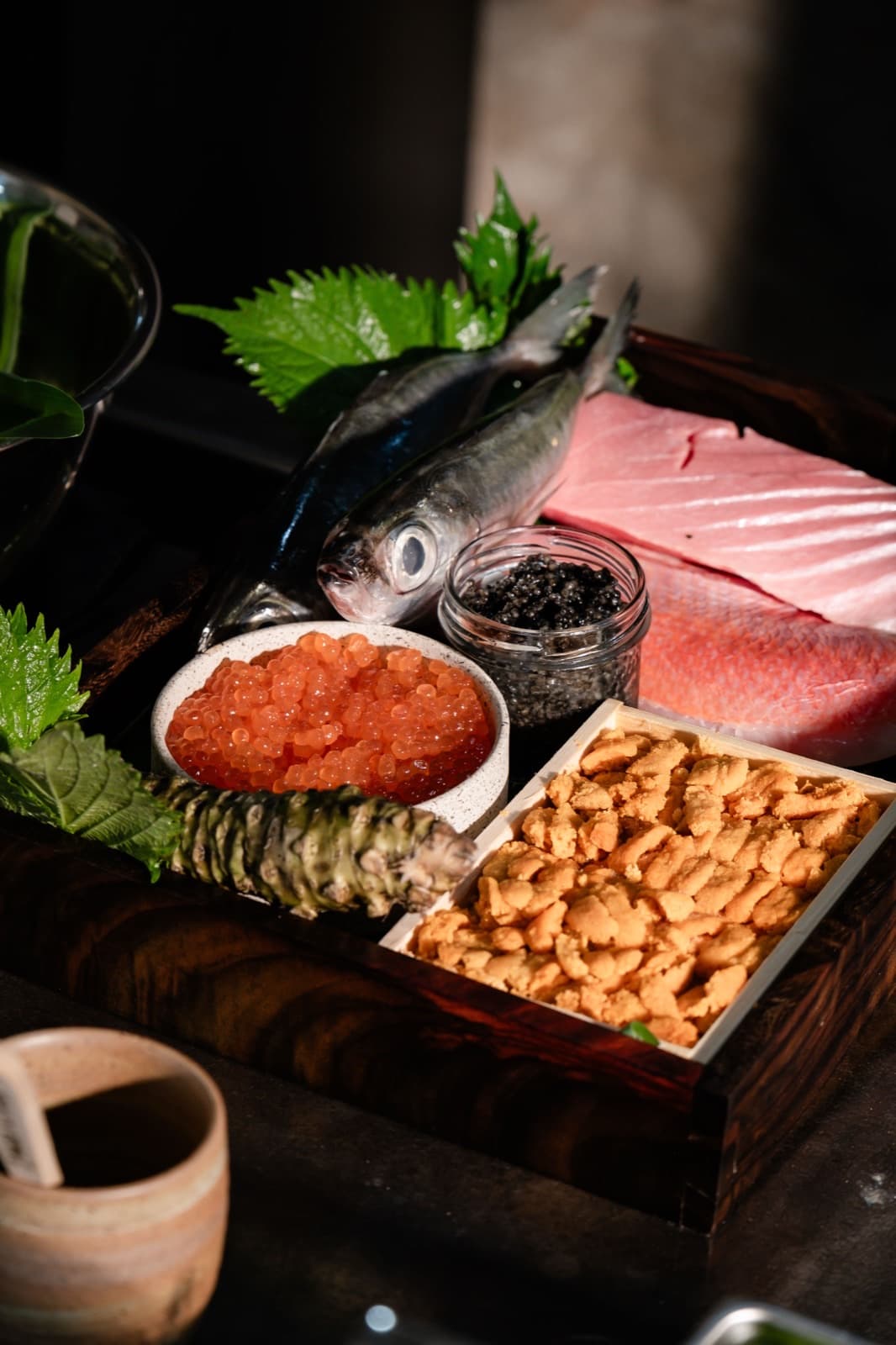 Fresh fish, salmon roe, caviar and sea urchin laid out with wasabi and shiso for a chef's-counter dinner at Kumo in Ubud.